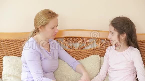 在柳条沙发上妈妈和女儿心连心地交谈视频的预览图