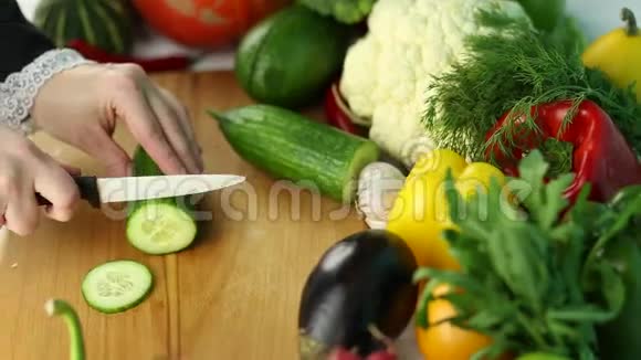 女人在新鲜蔬菜中切绿黄瓜视频的预览图