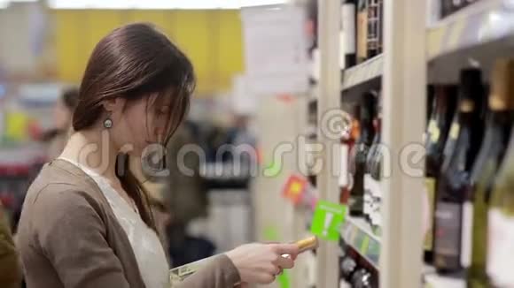 女人挑选商店货架上的酒视频的预览图