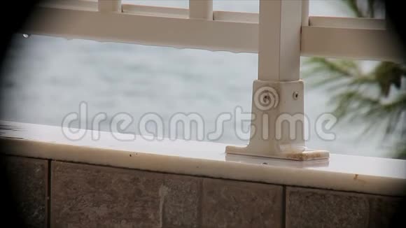 俯瞰大海的阳台上的雨视频的预览图