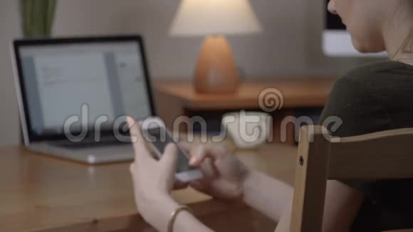 女性手持智能手机的特写镜头室内视频的预览图