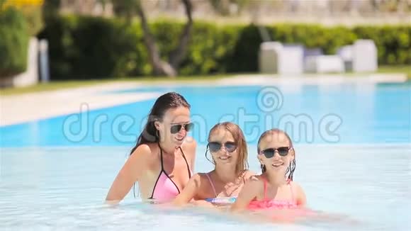 妈妈和两个孩子在豪华游泳池里享受暑假视频的预览图