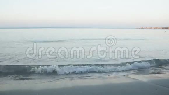 平静的蓝色海浪拍打着海岸线视频的预览图