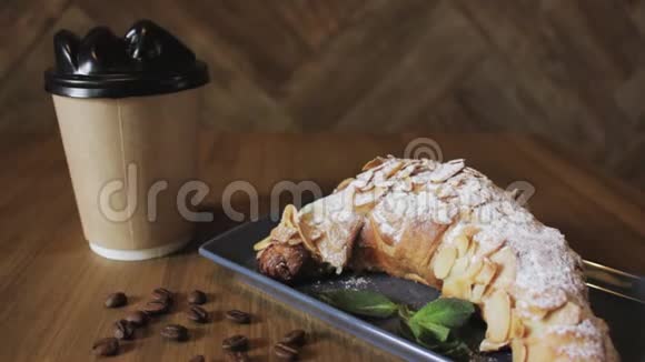 新鲜出炉的牛角面包薄荷叶和一杯咖啡放在木板上俯视有选择地聚焦视频的预览图