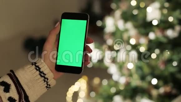 特写女性手触摸智能手机绿色屏幕Chroma键快关门跟踪运动模糊的圣诞节视频的预览图