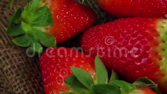 成熟多汁的草莓在黄麻麻布上视频的预览图