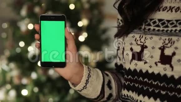 特写女性手触摸智能手机绿色屏幕Chroma键快关门跟踪运动模糊的圣诞节视频的预览图