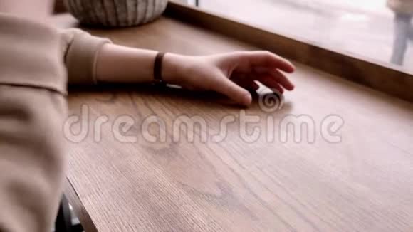 年轻女子在咖啡馆等着看着她手上的手表视频的预览图