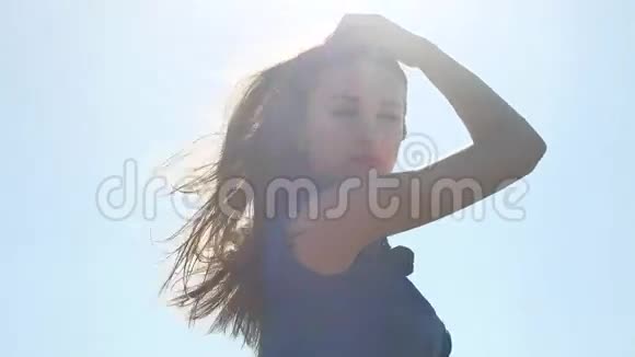 漂亮的女孩女孩的头发是在阳光下生长的视频的预览图