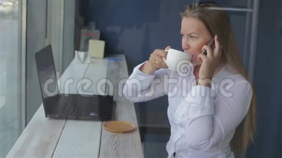 商务女性说话使用智能手机使用笔记本电脑视频的预览图