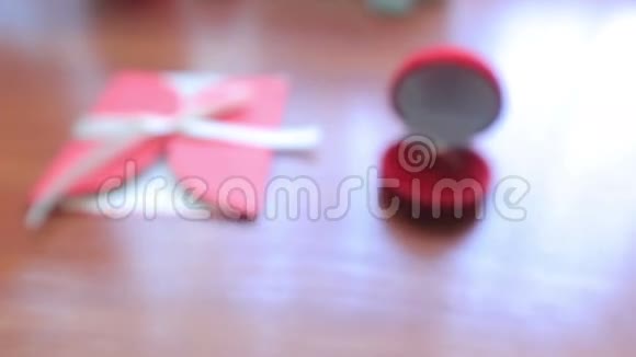 多莉红色盒子里的结婚戒指和桌上的明信片视频的预览图