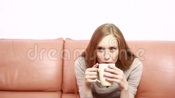 沙发上拿着杯子的翁美女画像视频的预览图