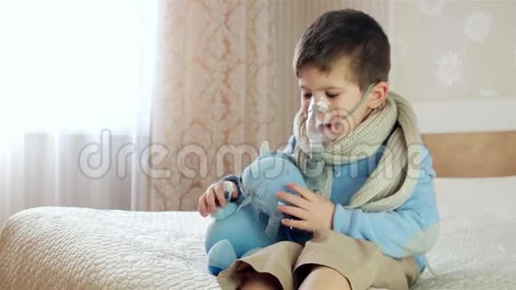 生病的孩子通过雾化器呼吸婴儿吸入男孩脸上戴氧气面罩在家治疗视频的预览图