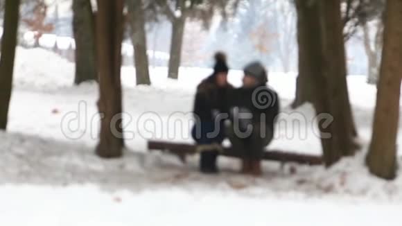 在童话般的冬天里一对年轻夫妇被一杯热饮料所温暖视频的预览图