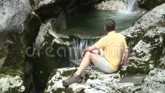 徒步旅行者在瀑布前休息视频的预览图
