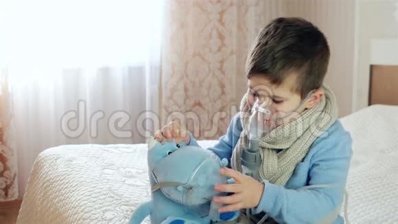 吸入雾化器生病的孩子通过雾化器呼吸婴儿吸入男孩戴着氧气面罩视频的预览图