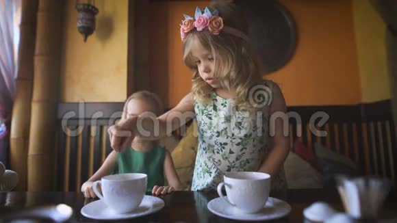 两个漂亮的小女孩在咖啡馆里喝茶视频的预览图