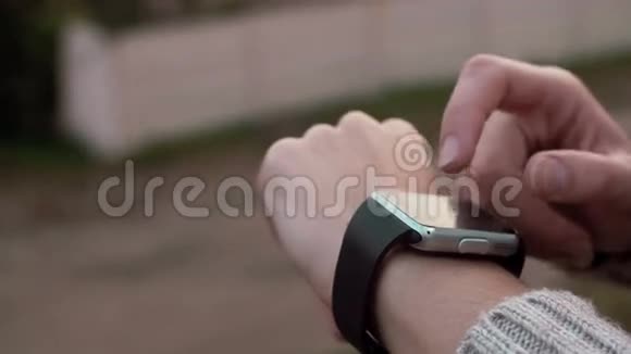 一位女士在农村背景下使用她的智能手表触摸屏设备视频的预览图