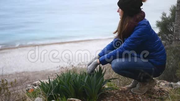 坐在岩石顶部的年轻女子视频的预览图
