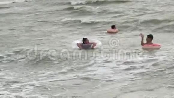 充气圈的人在海浪中游泳视频的预览图