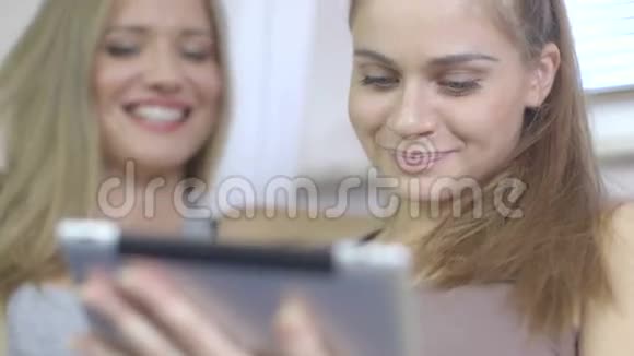 在客厅里用平板电脑拉近两位兴奋的美女视频的预览图