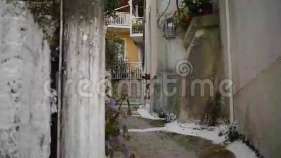 希腊花丛中狭窄阴凉街道的景色视频的预览图