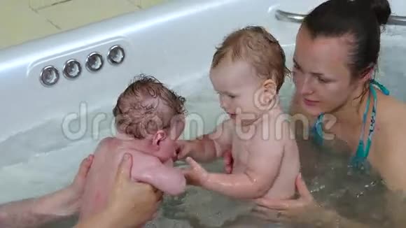 母亲带着她的孩子在按摩浴缸视频的预览图