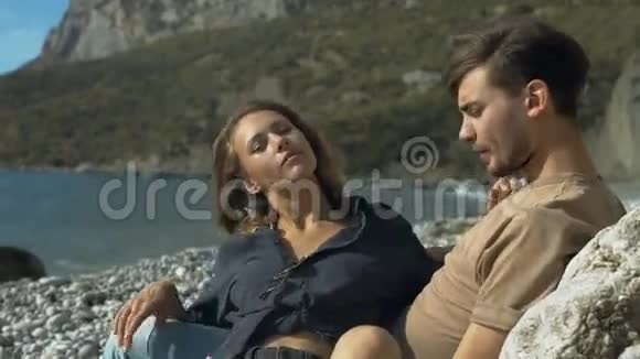 在海滩上放松的浪漫情侣视频的预览图