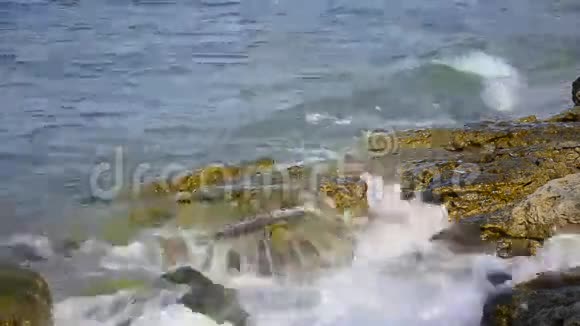 海滩上的波浪溅落在岩石上视频的预览图