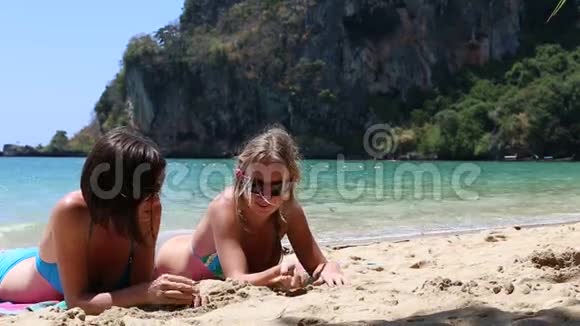 2两个小女孩在悬崖边沙滩上晒太阳视频的预览图