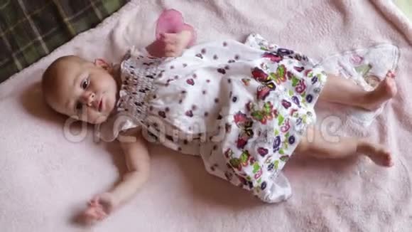 穿着漂亮衣服的小女孩躺在毯子上视频的预览图