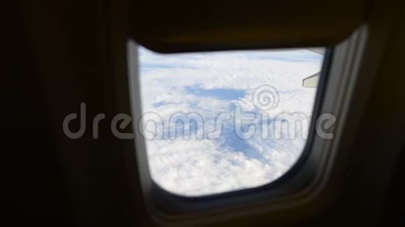 飞机机翼通过飞机窗口的视图在云层之上飞行视频的预览图