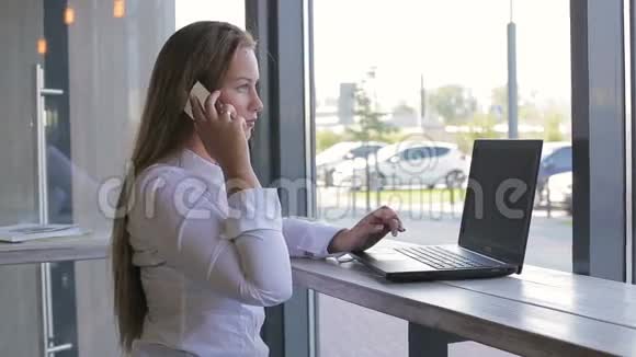 商务女性说话使用智能手机使用笔记本电脑视频的预览图
