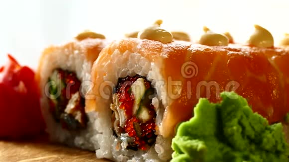 美味可口的寿司寿司配三文鱼片和新鲜黄瓜木头上有红姜和青芥末视频的预览图