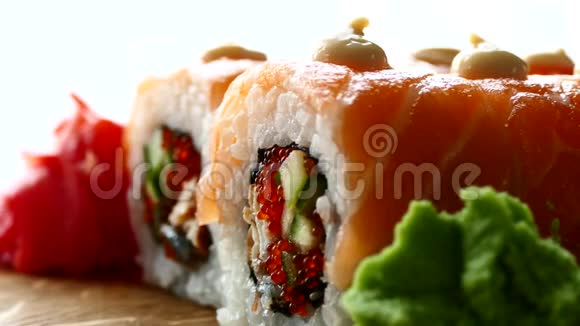 美味可口的寿司寿司配三文鱼片和新鲜黄瓜木头上有红姜和青芥末视频的预览图