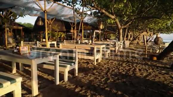 海滨餐厅提供木制长椅和桌子日出视频的预览图