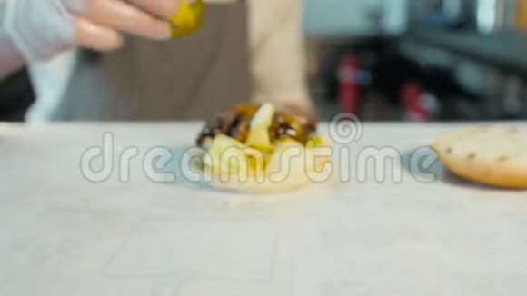 厨师在汉堡上添加配料准备和制作汉堡包快点吃汉堡视频的预览图