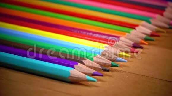 明亮的彩色铅笔在木制的表面上排成一排视频的预览图