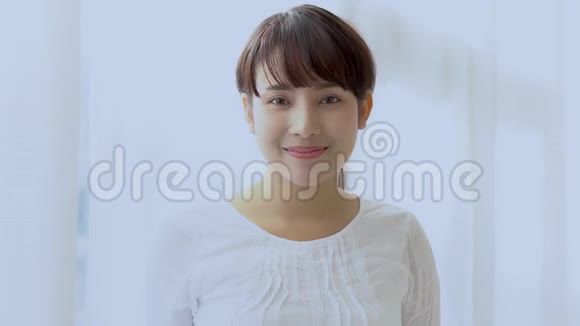 美丽的特写照片年轻的亚洲女人在卧室里笑着视频的预览图