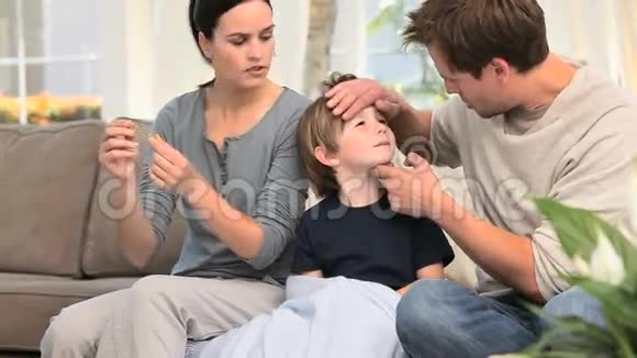 父母检查他们的儿子发烧视频的预览图