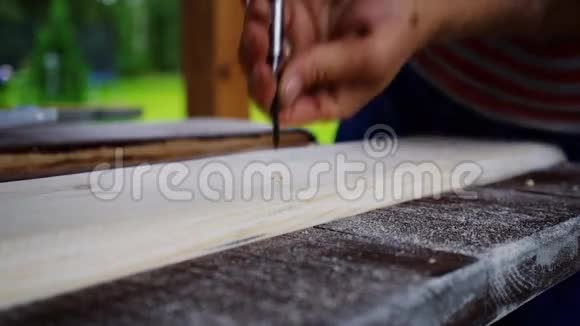 木工钻板上钻孔双手特写视频的预览图
