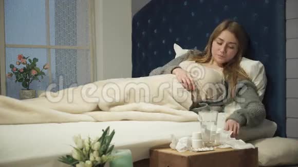 生病的女人躺在床上吃药视频的预览图