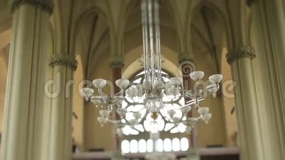 古老哥特式教堂内的大型现代吊灯视频的预览图