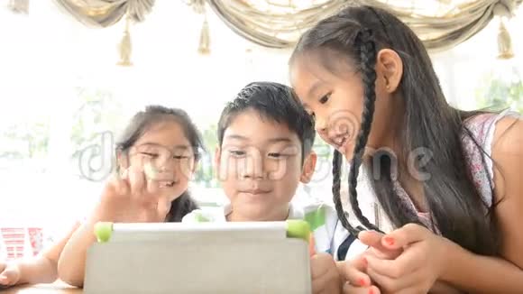 午餐期间一群亚洲儿童在玩触摸板视频的预览图