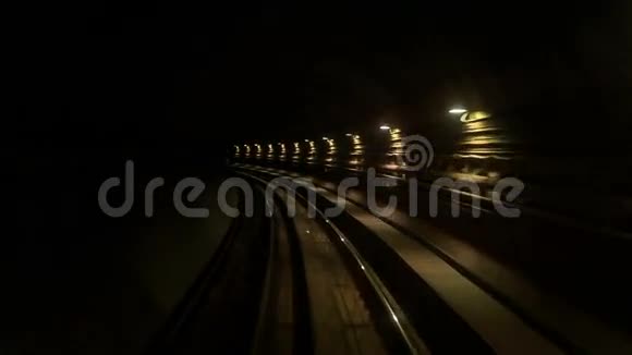摄像机沿着黑暗隧道的地铁轨道向后移动视频的预览图