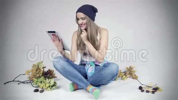 快乐的年轻女性使用白色背景的数字平板电脑视频的预览图