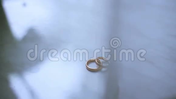 窗台上有两个金色结婚戒指上面有白色的奉承窗帘视频的预览图