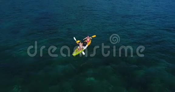 夏季白天在绿松石海中进行双人皮划艇的空中拍摄视频的预览图