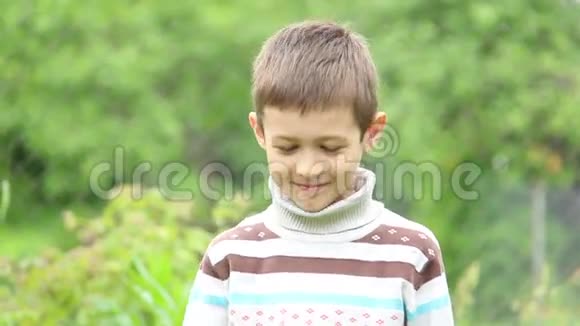 男孩在绿色背景特写镜头上吃草莓视频的预览图