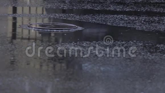 汽车车轮在雨中穿过下水道的人孔视频的预览图